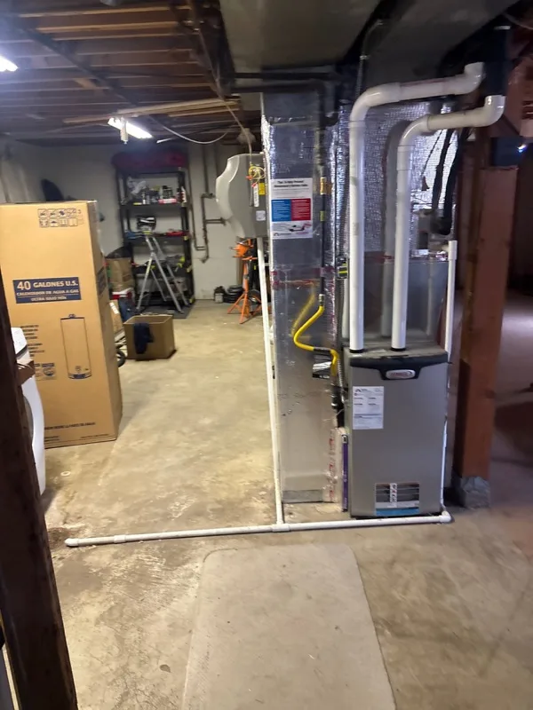 Basement furnace beside a boxed water heater in a Utah home