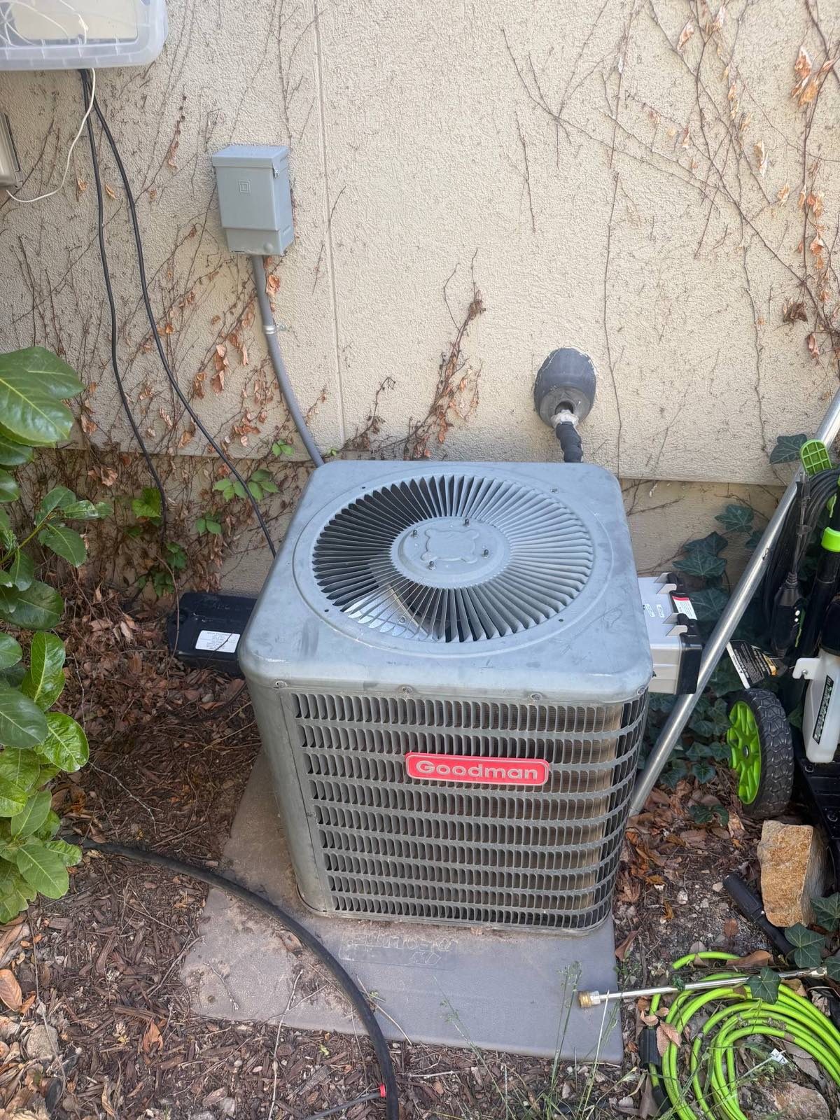 Weathered outdoor air conditioning condenser beside a home