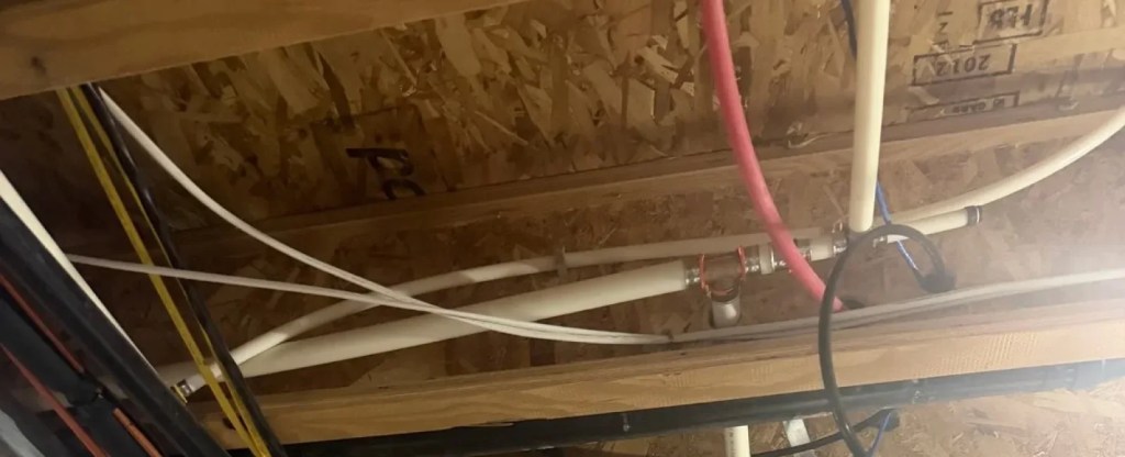 PEX water lines run through floor joists on a whole-home repipe by Rare Breed Plumbing in Utah