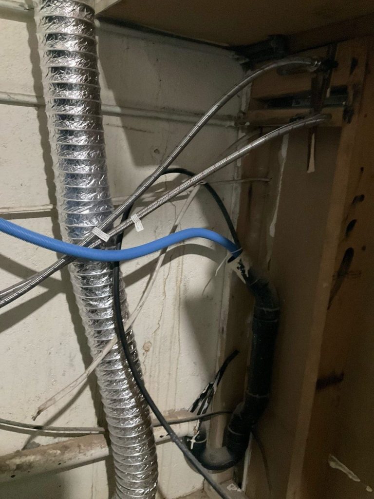 Flexible duct, blue PEX and conduit along a basement wall
