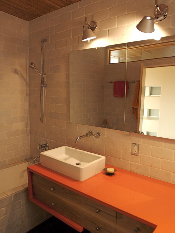 Modern bathroom with a vessel sink and an orange vanity top