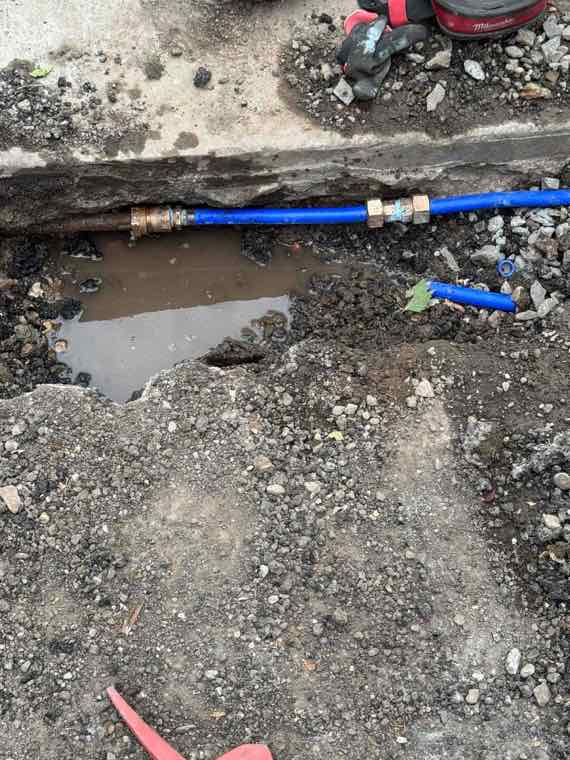 Blue water service line repaired in an excavated cut outside a Utah home