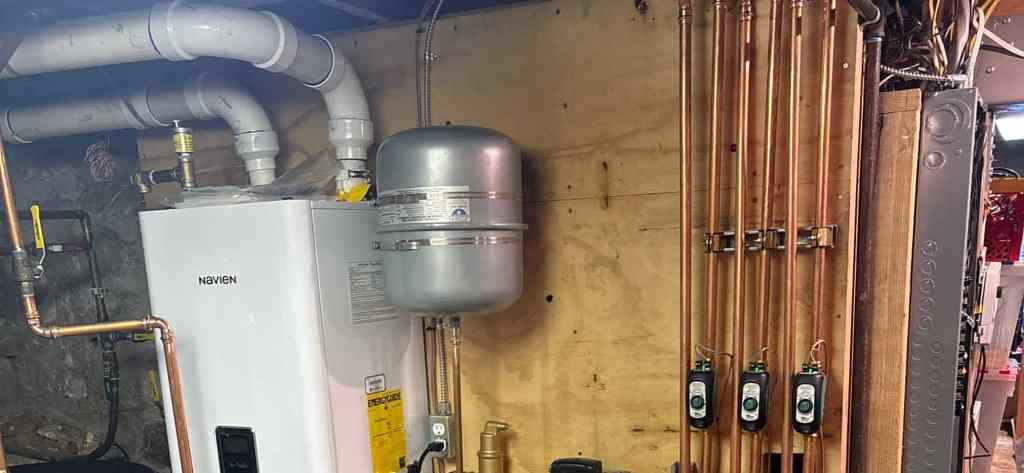 Wall-mounted Navien boiler with expansion tank and a copper zone manifold in a Utah mechanical room