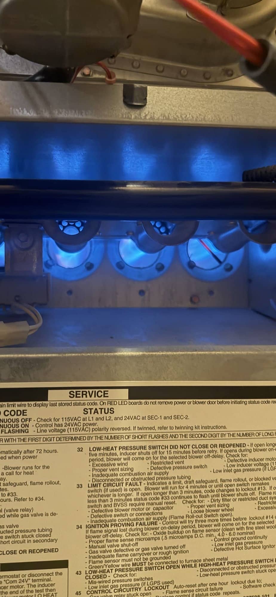 Gas furnace burners firing with a clean blue flame during a maintenance tune up in a Utah home