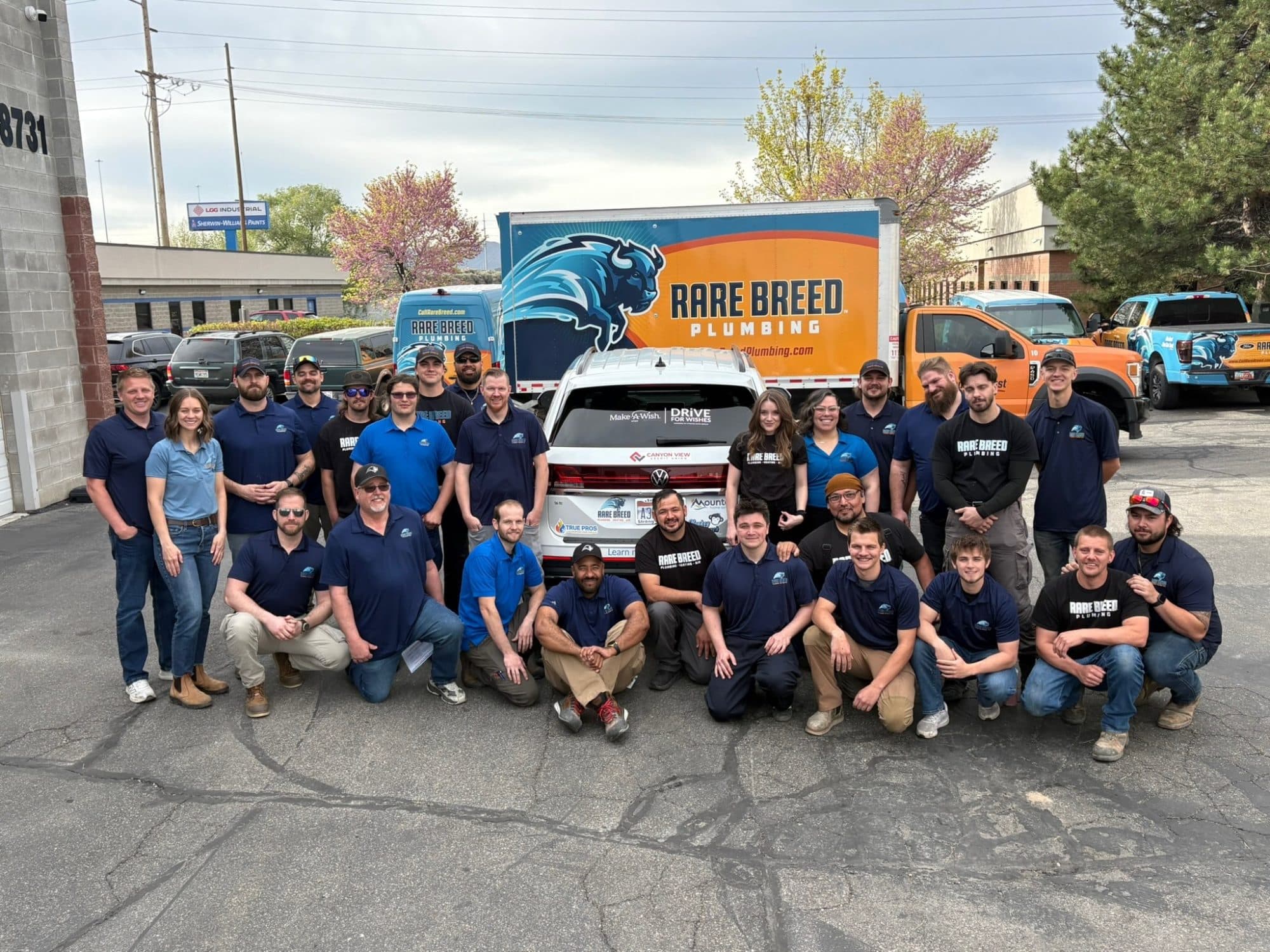 The Rare Breed Plumbing, Heating and Air team gathered in front of a branded box truck and service vehicles