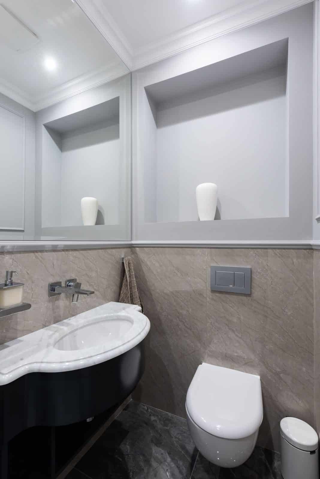 Modern bathroom with a wall-hung toilet, marble vanity, and dual-flush plate